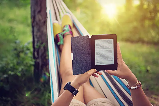 A girl is reading e-book in the hammock. different types of ebooks 