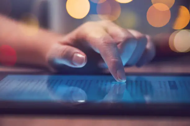 Woman reading online news on digital tablet